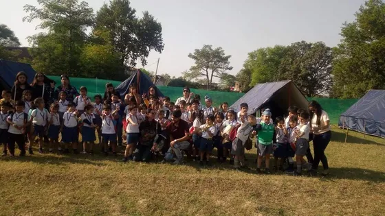 Students cheering together outside camp tents